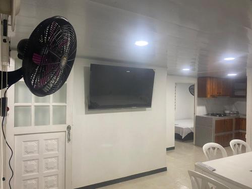 a living room with a fan hanging on a wall at FInCA LA BENDICIÓN DE SUNNYVALE in La Vega