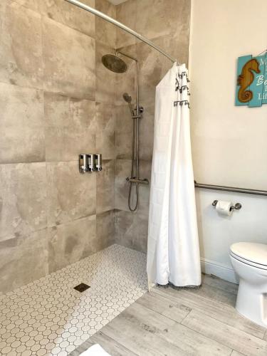 a shower with a shower curtain in a bathroom at The Banana Bird at Cottages in Sand Bluff