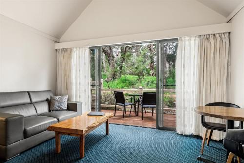 a living room with a couch and a table at Heritage Trail Lodge in Margaret River Town