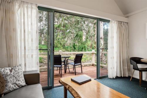 a living room with a couch and a table with chairs at Heritage Trail Lodge in Margaret River Town