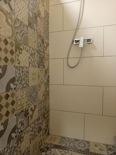 a shower with a shower head in a bathroom at Apartmani Piralis in Bihać