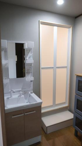 a bathroom with a sink and a mirror at Sakura house in Tokyo