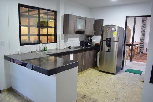 a kitchen with a refrigerator and a counter top at Finca La Fortaleza in Tuluá