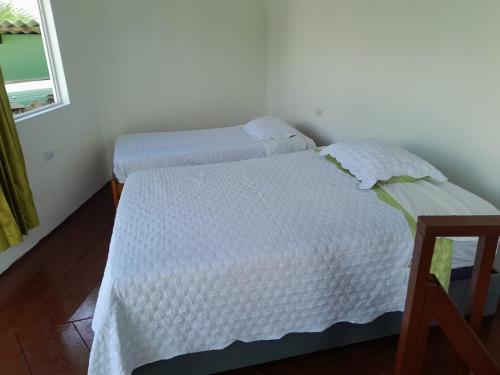 a bedroom with two beds and a window at CABAÑA PATIO ESPAÑOL in Santa Veronica