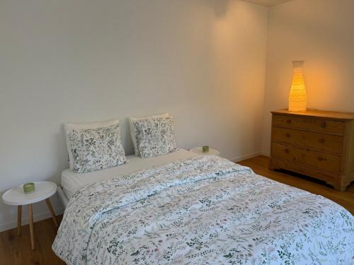 a bedroom with a bed and a dresser with a lamp at Landluft in Stadtnähe in Rapperswil-Jona