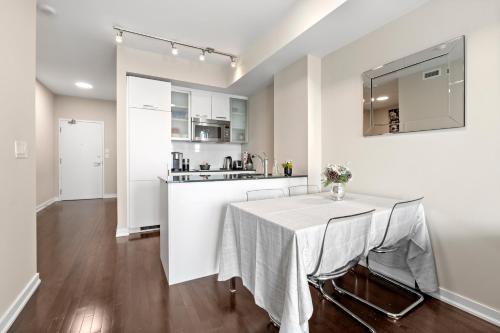 a kitchen and dining room with a table with chairs at Luxury Lakeview Downtown Condo, CN Tower, Rogers Center, Scotia Arena, Lake View with Free Parking in Toronto