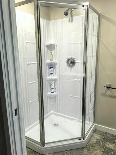 a shower with glass doors and shelves in a bathroom at Private Cozy 2bdrm Sleep5pp Metrotown! Free Parking! Self Check-in! in Burnaby