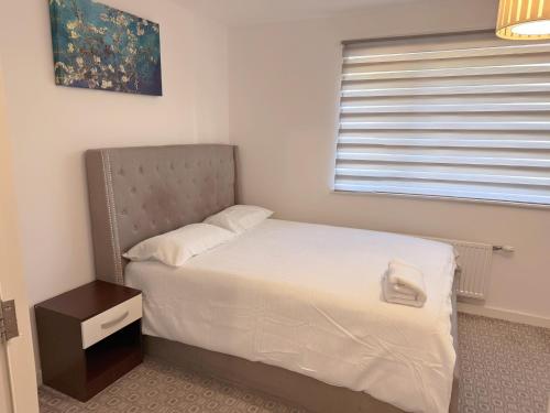 a small bedroom with a bed and a window at Modern Home with Private Garden and Car Park in Manchester in Little Hulton