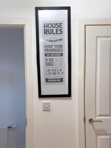 a picture hanging on a wall next to a door at Modern Home with Private Garden and Car Park in Manchester in Little Hulton