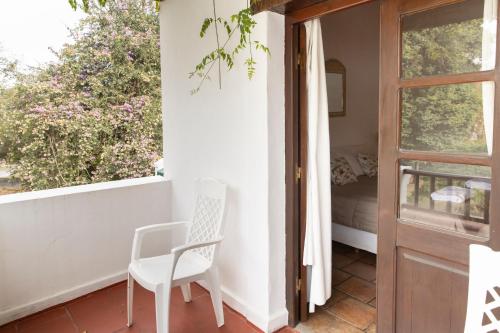 a white chair sitting on a balcony next to a door at Las Moras Hotel in San Lorenzo