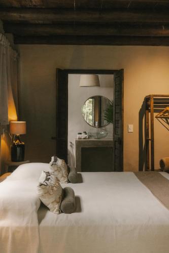 a bedroom with a large white bed and a mirror at CASA SUKHA Hotel in Trancoso