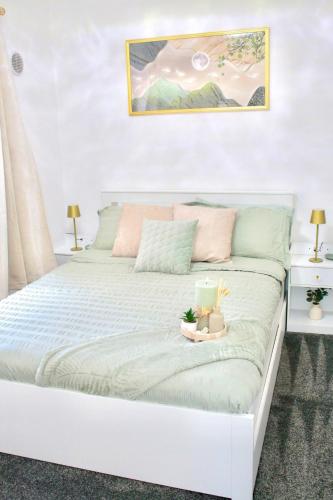 a white bed with a tray on top of it at Cardiff - Sleep 7- Hot tub, Sauna in Cardiff
