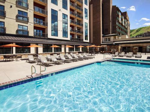 a large swimming pool with chairs and a hotel at Sheraton Steamboat Resort Villas Hotel Apartment with Resort Access in Steamboat Springs