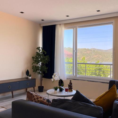 a living room with a couch and a large window at Sea View Getaway 2BR Flat Walk to Shorelin in Bogazici