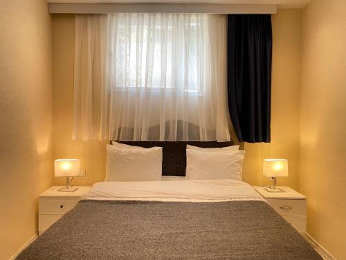 a bedroom with a bed with a window and two lamps at Sea View Getaway 2BR Flat Walk to Shorelin in Bogazici