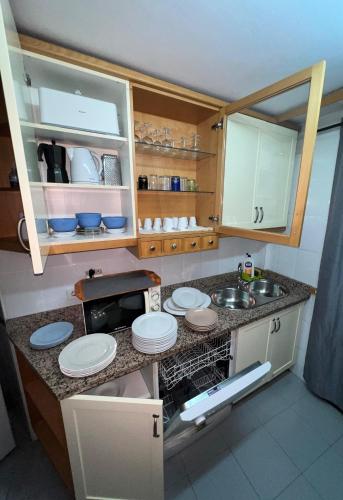 a small kitchen with a sink and plates on a counter at Casa centro casco histórico in Córdoba
