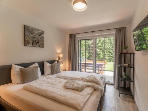 een slaapkamer met een groot bed met een raam bij Tauernlodge Eben C1 in Eben im Pongau