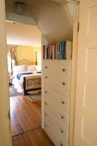a bedroom with a bed and a dresser with books at Scranton Seahorse Inn in Madison