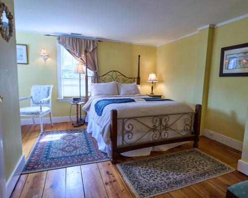a bedroom with a bed and a chair and a window at Scranton Seahorse Inn in Madison