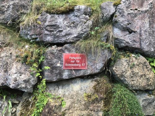 a sign on a pile of rocks with grass at Schneeberghütte in Hinterthiersee