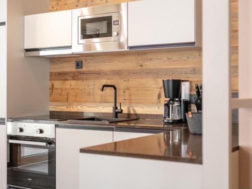 a kitchen with a sink and a microwave at Hopfgarten Alpin Living Top 3 in Hopfgarten im Brixental