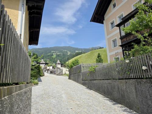 an empty road next to a building with a fence at Hopfgarten Alpin Living Top 3 in Hopfgarten im Brixental