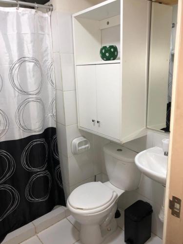 a bathroom with a white toilet and a sink at Departamento Condominio Club Carabayllo in Carabayllo