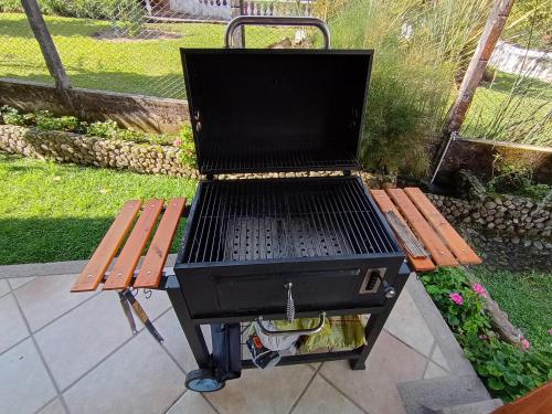 a barbecue grill sitting on a picnic table next to a bench at La muñeca Chalet in Circasia