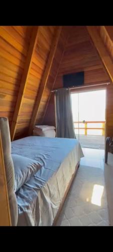 a large bed in a room with a wooden ceiling at Chalé Parada do Vale in Planalto