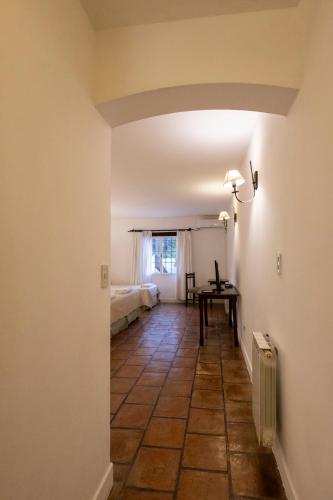 a hallway with a room with a bed and a table at Las Moras Hotel in San Lorenzo