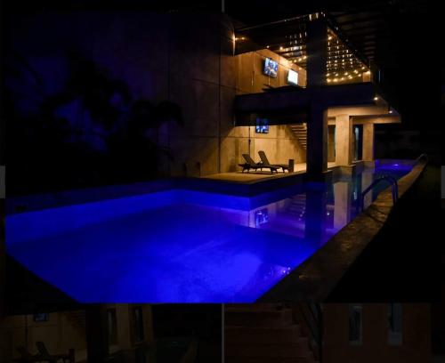 a swimming pool at night with blue lighting at Alojamiento las americas in Mérida