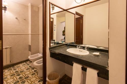 a bathroom with a sink and a toilet and a mirror at Las Moras Hotel in San Lorenzo