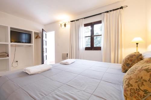 a bedroom with a large white bed with a window at Las Moras Hotel in San Lorenzo