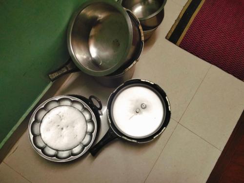 two pans with a white candle in them on a table at Thendralhomestay in Puducherry