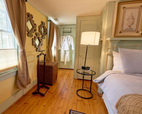 a bedroom with a bed and a lamp and a window at Scranton Seahorse Inn in Madison