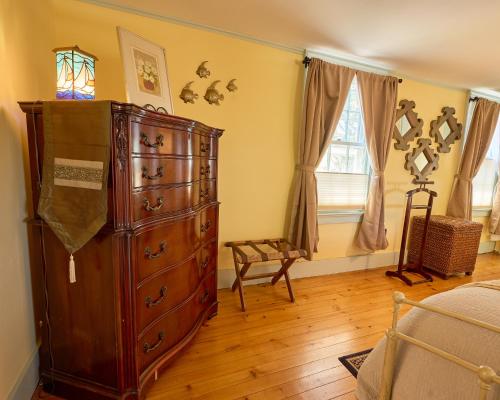 a bedroom with a large wooden dresser and a window at Scranton Seahorse Inn in Madison