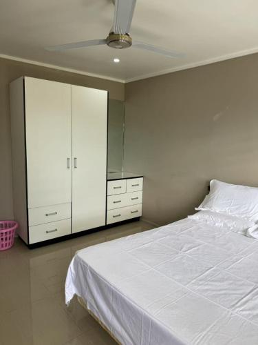 a bedroom with a white bed and a mirror at Beverly Hills-3 Bedroom House in Nadi