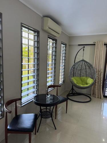 a room with a swing and a table and chairs at Beverly Hills-3 Bedroom House in Nadi