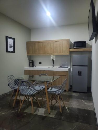 a kitchen with a table and chairs in a room at Alojamiento las americas in Mérida
