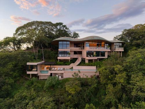 a building on top of a hill with trees at Villa Coral in Nacascolo