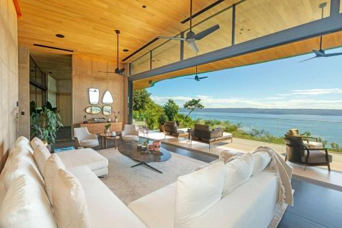 a living room with a white couch and a view of the ocean at Villa Coral in Nacascolo