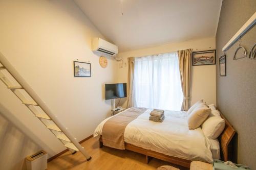 a small bedroom with a bed and a staircase at Sand Beige 7mins yokosukachuo station 2-4pax in Yokosuka