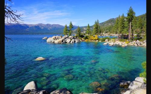 a large body of water with rocks and trees at Fully Renovated Northstar Lake Tahoe Retreat in Truckee