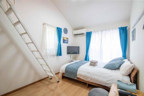 a bedroom with a bed with blue curtains and a ladder at Blue Marina Yokosuka - 7-minute walk from Yokosuka Chuo station, 2-4pax in Yokosuka