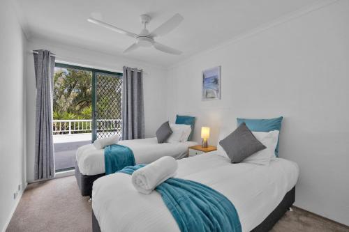 two beds in a room with a window at A Noosa River gem, central and family friendly in Noosaville