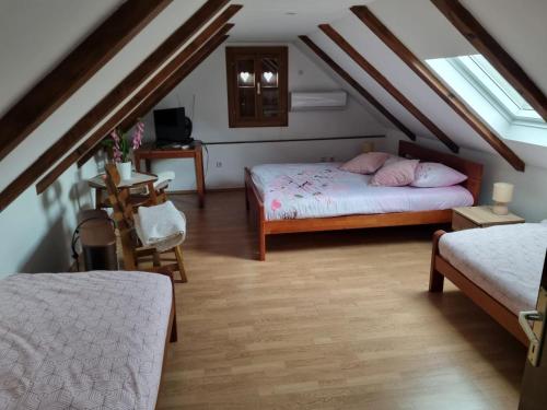 ein Schlafzimmer im Dachgeschoss mit zwei Betten und einem Tisch in der Unterkunft Holiday Home Katica - Two-Bedroom Holiday Home in Donja Stubica