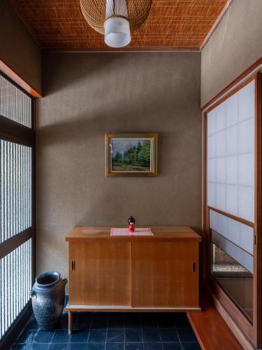 a room with a table and a vase on the floor at Private Lodge 春夏秋冬 -SHIKI- in Shibukawa