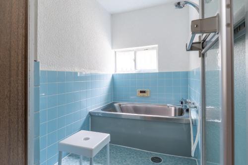 a bathroom with a sink and blue tiles at Atlantis 天下茶屋 in Osaka