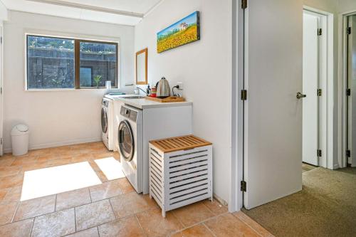 a laundry room with a washing machine and a window at Horizon View in Coromandel Town
