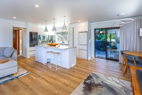 a kitchen and living room with a couch and a table at Horizon View in Coromandel Town